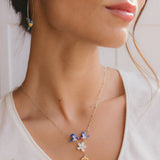 Necklace featuring a pair of swallows, a flower, and an orange