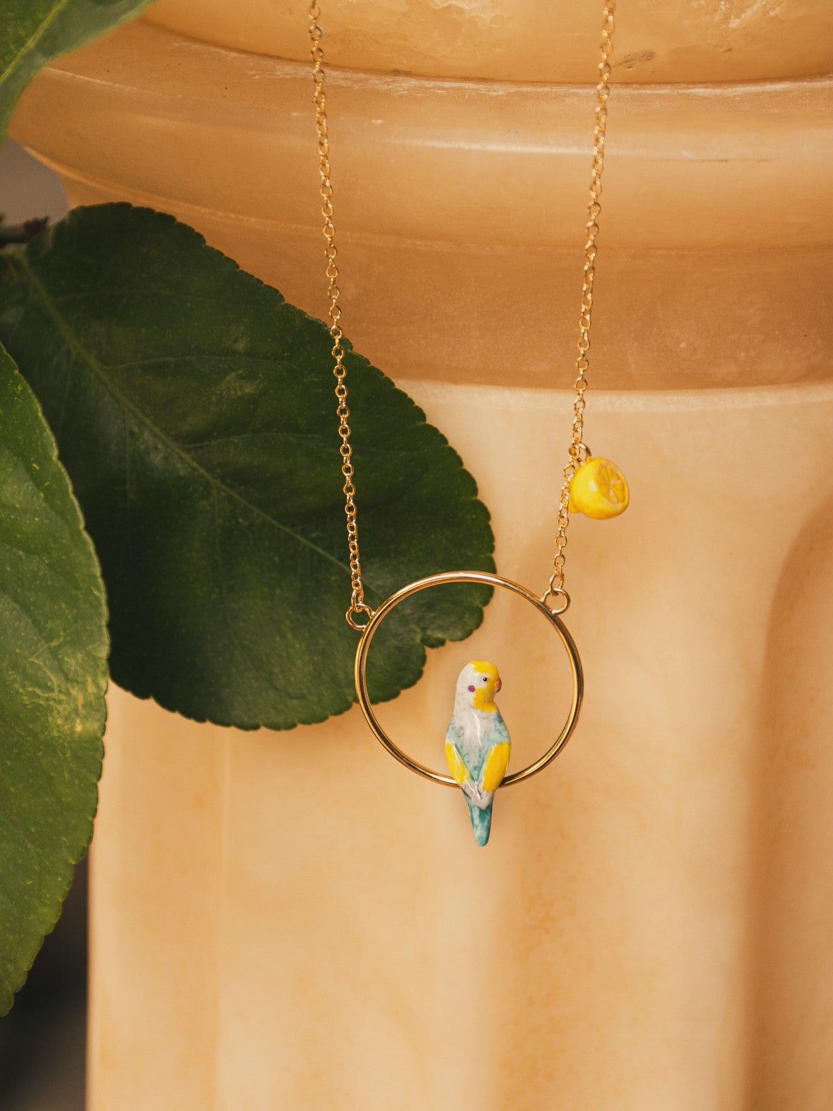 collier doré rond perruche bleue jaune oiseau citron porcelaine
